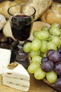 Red wine with some grapes,cheese and bread. Royalty Free Stock Photo