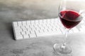 Red wine spilled over computer keyboard on concrete table with f