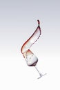 Red wine splashing out of a glass, isolated over white background Royalty Free Stock Photo