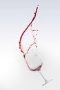 Red wine splashing out of a glass, isolated over white background Royalty Free Stock Photo