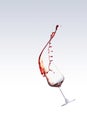 Red wine splashing out of a glass, isolated over white background Royalty Free Stock Photo