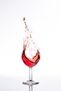 Red wine splashing out of a glass, isolated on white Royalty Free Stock Photo