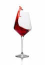 Red wine splashing out of a glass isolated on white Royalty Free Stock Photo