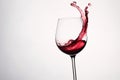 Red wine splashing out of a glass, isolated on white background - Ai Generated Royalty Free Stock Photo