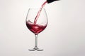 Red wine splashing out of a glass, isolated on white background - Ai Generated Royalty Free Stock Photo