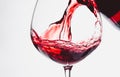 Red wine splashing out of a glass, isolated on white background Royalty Free Stock Photo