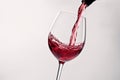 Red wine splashing out of a glass, isolated on white background - Ai Generated Royalty Free Stock Photo