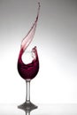 Red wine splashing out of a glass Royalty Free Stock Photo