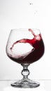 red wine splashing out of a glass, on white bacground Royalty Free Stock Photo