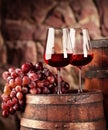 Red wine.Still life two glasses of red wine, grapes and barrel.Selective focus.Wine cellar atmosphere.Copy space Royalty Free Stock Photo