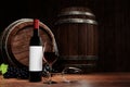 Red wine in tall clear glass beside dark wine bottle. Wine fermentation tank is made of wood. wooden barrel in the cellar, Tasting Royalty Free Stock Photo