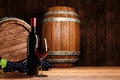 Red wine in tall clear glass beside dark wine bottle. Wine fermentation tank is made of wood. wooden barrel in the cellar, Tasting Royalty Free Stock Photo