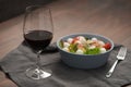 Red wine in thin wine glass with salad in blue bowl