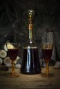 Red Wine Vintage Bottle and Glasses Resting On Wooden Table Against Christmas Background With Wood logs and Pine Branches Royalty Free Stock Photo