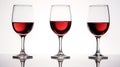 Red wine on a white background. Three wine glasses are reflected on a glossy white table. Front view, close up Royalty Free Stock Photo
