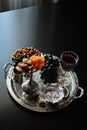 Red wine, wineglass with walnuts, grapes and figs on dark wooden background