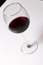 Red wine on a wineglass on a white background