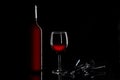Red wineglass, wine bottle and corkscrew and black background with copy space for your text