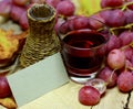 Red wines homemade wicker bottle and grapes Royalty Free Stock Photo