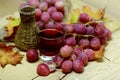 Red wines homemade wicker bottle and grapes Royalty Free Stock Photo