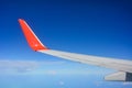 Red wing of the aircraft view from airplane window seat flying in the blue sky with white clouds background, copy space Royalty Free Stock Photo