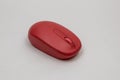 Red wireless computer mouse on a flat surface