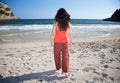 Red woman walking towards sea Royalty Free Stock Photo