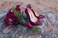 Red women`s shoes with red wedding bouquet