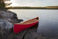 Red wood canoe on rocky island in the Boundary Waters on a bright autumn morning