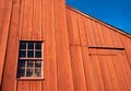 Red wood frame barn siding against a blue sky Royalty Free Stock Photo