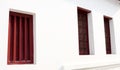 Red wood window row and white painted concrete wall. Royalty Free Stock Photo