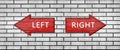 Red wooden arrow signs with the inscription LEFT and RIGHT hang on a white brick wall. Right and left arrow pointers. Set Royalty Free Stock Photo