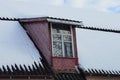 Red wooden attic with a window on a gray tiled roof Royalty Free Stock Photo