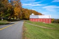 Red wooden barn along a country road in autumn Royalty Free Stock Photo