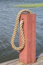 Red wooden boat bollard and rope Royalty Free Stock Photo