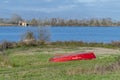 A red wooden boat is capsized near the shore of the Gherardesca lake, Lucca, Italy Royalty Free Stock Photo