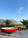 Red wooden boat and yellow kayaks on the seafront. Seaview, mountain and palms