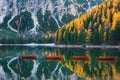 Red wooden boats on Braies lake at sunrise in autumn in Dolomites Royalty Free Stock Photo