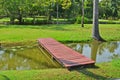 Red wooden bridge over small canal in the park Royalty Free Stock Photo