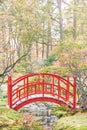 Red wooden bridge over small creek in a Japanese garden Royalty Free Stock Photo