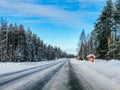 Red wooden bus stop covered by snow in winter countryside in Lapland Finland. Snow winter landscape with road and  forest Royalty Free Stock Photo