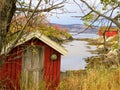 Red wooden cabin in rural Norwegian fjord Saltstraumen