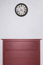 red wooden cabinet and clock in empty room with white cement wall background. vintage style Royalty Free Stock Photo