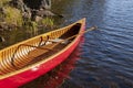 Red wooden canoe in the water by the shore of a northern Minnesota lake Royalty Free Stock Photo