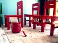 Red wooden chairs and a container of red paint Royalty Free Stock Photo
