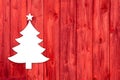 Red wooden christmas background with a white tree.