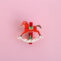 Red wooden Christmas and New Year decoration in the form of horse on a pink background. Royalty Free Stock Photo