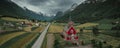 Red wooden church of Olden with road in the fjord Nordfjord in summer in Norway from above