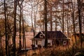 Red wooden cottage in the autumn forest. Relaxing place, ideal for weekend and vacation rental. Retreat place. Royalty Free Stock Photo