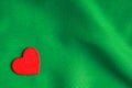 Red wooden decorative heart on green folds background. Royalty Free Stock Photo